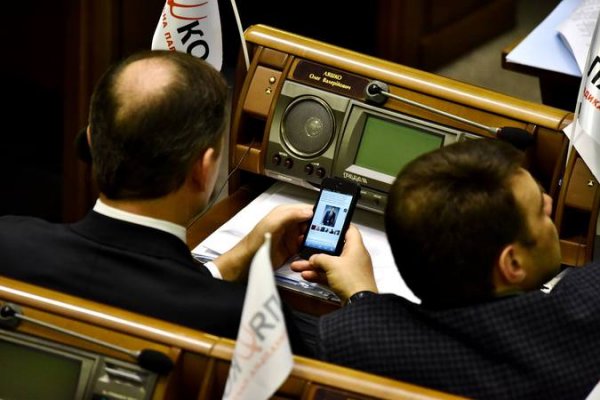 На заседании Верховной Рады Олег Ляшко рассматривает фото голых мужчин